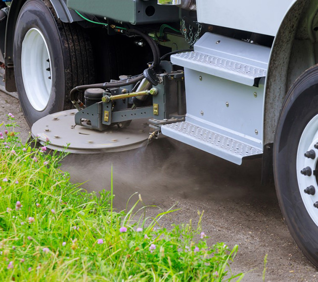 Street Sweeping Services in the Grand Rapids, Michigan area-image of street sweeper truck side broom